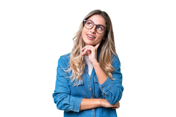Young Uruguayan woman over isolated background looking up while smiling