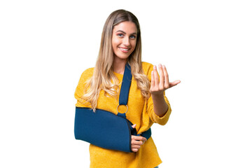 Young Uruguayan woman with broken arm and wearing a sling over isolated background inviting to come with hand. Happy that you came