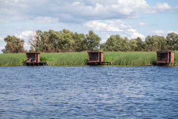 Wooden gazebos stand on far bank of summer river
