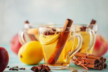 Homemade Wassail Mulled Apple Cider with Lemon and Spices in glasses. Winter alcoholic hot drink.
