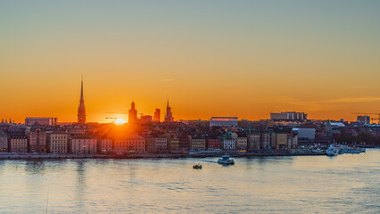 Sunset over the old town of Stockholm, skyline of Gamla Stan, silhouette of churches and famous...