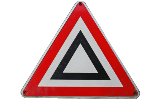 Close-up of a reflective triangular road sign warning drivers to yield, commonly found at intersections and road merges.
