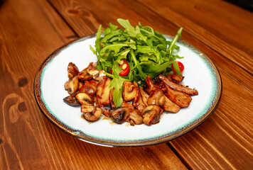 Salad of fried vegetables and mushrooms, eggplant, with fresh arugula and pine nuts. Vegetable salad with grilled champignons and cherry tomatoes. Healthy vegetarian food.
