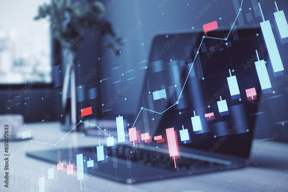 Poster a laptop displaying stock market chart graphics with a holographic overlay concept on a modern offic