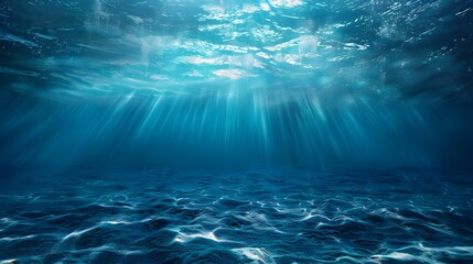 A deep blue ocean with light shining down, viewed from the bottom of an underwater scene. The water is calm and serene, creating a sense of tranquility and vastness in its depth.