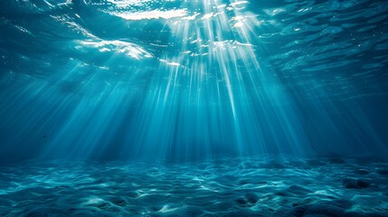 A deep blue ocean with light shining down, viewed from the bottom of an underwater scene. The water is calm and serene, creating a sense of tranquility and vastness in its depth.