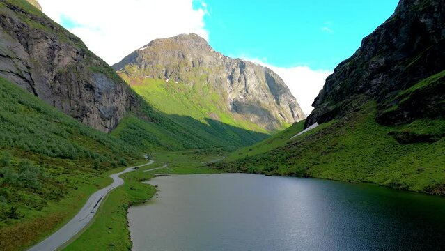 A scenic video of a beautiful lake in a mountain valley, surrounded by majestic peaks. A subtle addition at the bottom adds elegance to the tranquil scene, Norweigan Fjords Stavbergvatnet Urke