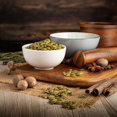 PUMPKIN SEEDS on wooden table background. Herbs, spices and dried food baking ingredient. Mortar and different spices. Cottage kitchen. Product Photography