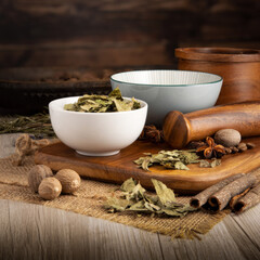 CURRY LEAVES KARI PATTAT on wooden table background. Herbs, spices and dried food baking ingredient. Mortar and different spices. Cottage kitchen. Product Photography