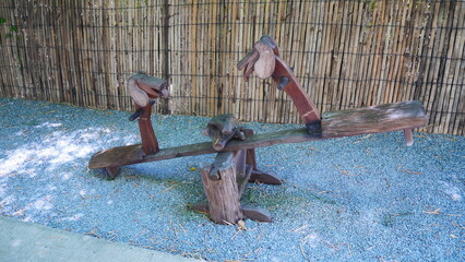A seesaw made of wood is a toy for children