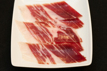 White plate with cut Iberian ham