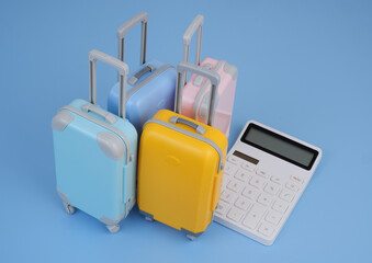 Many suitcases and calculator on blue background.