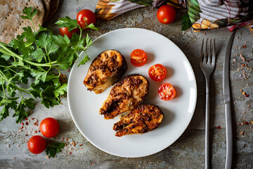 Dinner dish for the whole family: Grilled fish steaks on a beautiful plate on a gray background. Grilled salmon steaks with spices on plates. View from above
