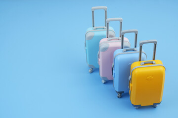 Many different colorful suitcases on blue background. Copy space for text. Travel and vacation concept.