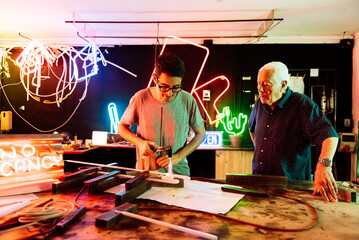 Father and Son Working together on a Neon Sign in a Family-Owned