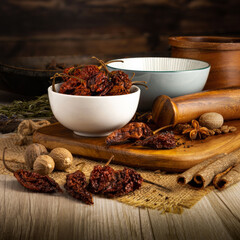 NAGA GHOST CHILLI DRIED PODS on wooden table background. Herbs, spices and dried food baking ingredient. Mortar and different spices. Cottage kitchen. Product Photography