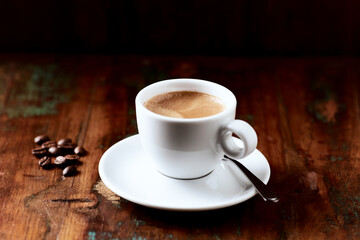 Cup of coffee on wooden background.