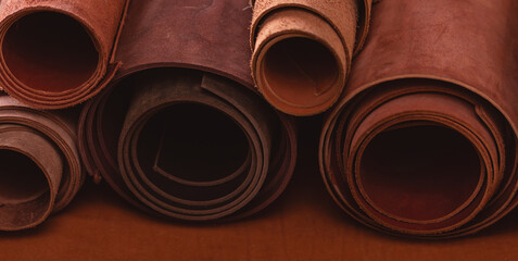 Brown rolled leather in shoemaker workshop, background tailor footwear industry