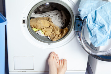 Woman legs in front of a washing machine....