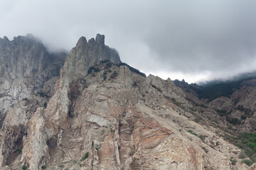 top of  stern cliff  in clouds.