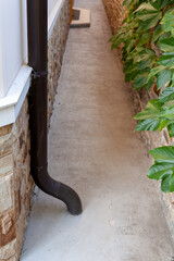 Drainpipe runs along wall and goes underground..