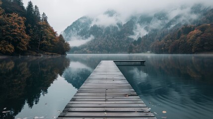 Tranquil Wooden Dock Leading Towards Foggy Mountains