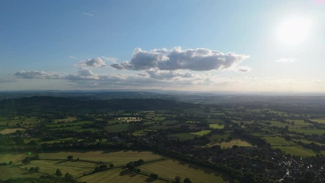 Aerial view of beautiful british countryside with sun shining over farmland
