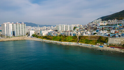 Obraz premium aerial view of Huinnyeoul Culture Village in Busan, Korea. The picture showcases a coastal village with a terraced landscape, colorful buildings, and a beautiful seafront.