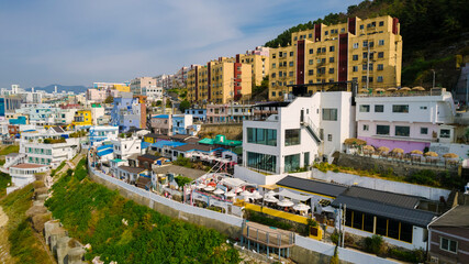 aerial view of Huinnyeoul Culture Village in Busan, Korea. The picture showcases a coastal village with a terraced landscape, colorful buildings, and a beautiful seafront.