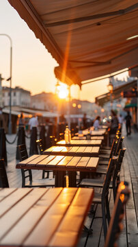 terrasse de caf&eacute; avec table en bois &eacute;clair&eacute;e par les derniers rayons du soleil 