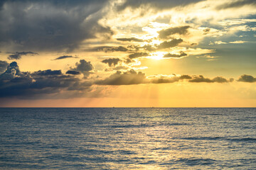 Fototapeta premium Sea beach with sky sunset or sunrise. Cloudscape over the sunset sea. Sunset at tropical beach. Nature sunset sky of sea. Dramatic clouds.