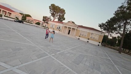 Multiethnic dance partners dancing to music in city, 360 drone shot