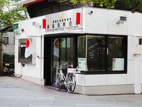 TOKYO, JAPAN - May 5, 2024: A police box in Tokyo's Akasaka area. Japanese national flags are flying because it's a National Holiday. 