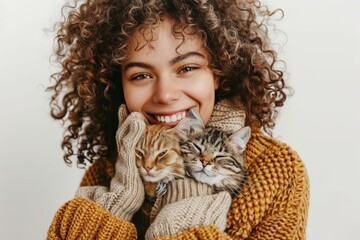 A woman with curly hair is holding a cat in her arms