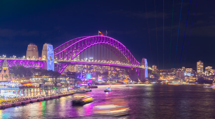 Colourful Light show at night on Sydney Harbour NSW Australia. The bridge illuminated with lasers and neon coloured lights 