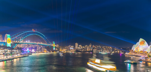 Obraz premium Colourful Light show at night on Sydney Harbour NSW Australia. The bridge illuminated with lasers and neon coloured lights 