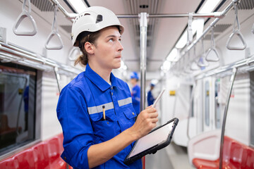 Portrait of young engineer of electric locomotive holding tablet in train