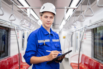 Portrait of young engineer of electric locomotive holding tablet in train