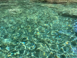 Clear transparent water with stones pebbles on seabed