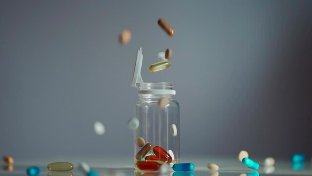 different pills falling into transparent bottle, drugs variety and medicines addiction, antidepressant and vitamins supplement concept
