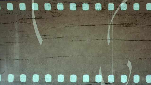 Closeup of film strip on brown background with doodle grunge lines. Dust and scratches. High quality 4k footage