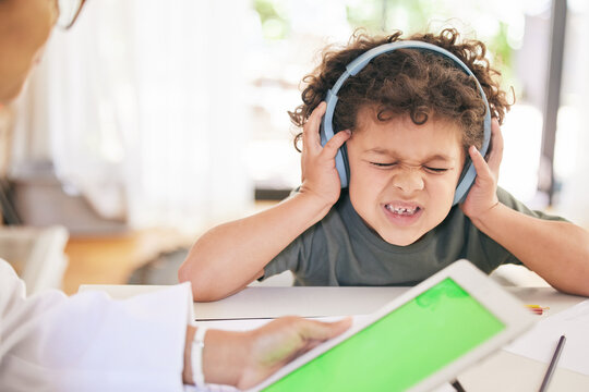 Boy, headphones and doctor or tablet for stress test, autism diagnosis and sensory overwhelmed. Male person, child and audio or sound for anxiety or pain, online and green screen and psychologist - Powered by Adobe
