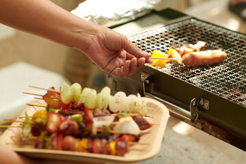Closeup image of woman grilling food for party guests
