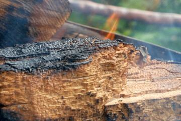 firewood on fire and smoke on the grill in summer day, closeup