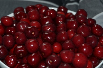Red cherry in a bowl. Red sweet cherry background.