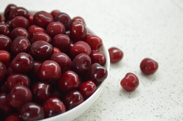 Red cherry in a bowl. Red sweet cherry background.