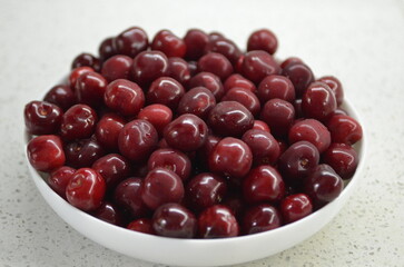 Red cherry in a bowl. Red sweet cherry background.