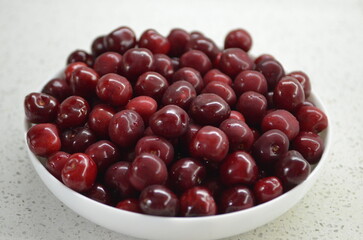 Red cherry in a bowl. Red sweet cherry background.