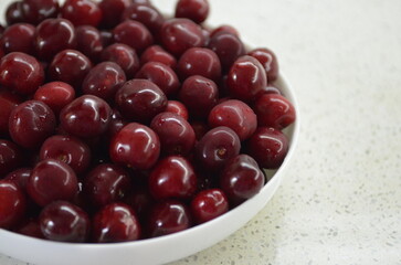 Red cherry in a bowl. Red sweet cherry background.