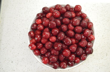 Red cherry in a bowl. Red sweet cherry background.